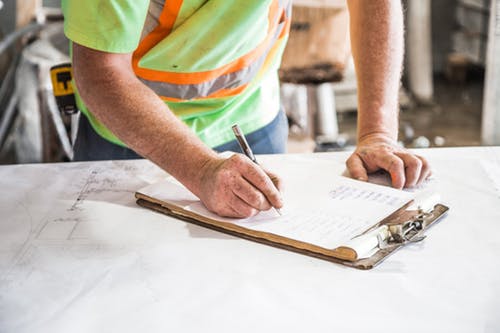 inspector writing on a clipboard