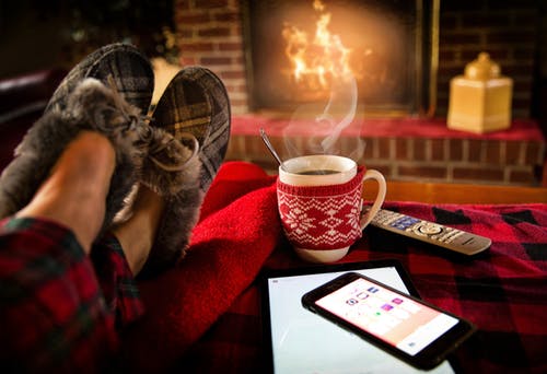 Warming feet by the fire with a warm coffee